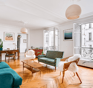 Salon parisien en parquet point de Hongrie, fauteuils et balcon en fer forgé